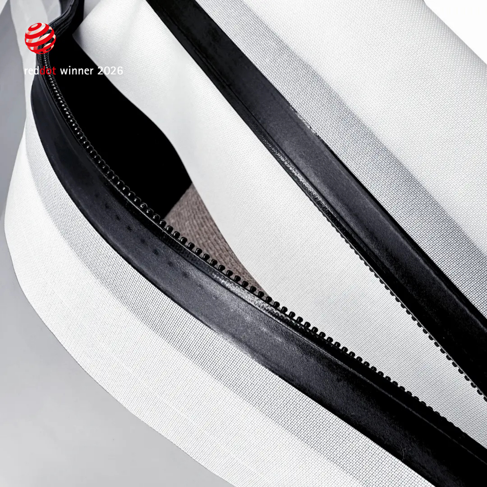 Extreme close-up of the black airtight zipper running along a white TILLIV Compak pack
