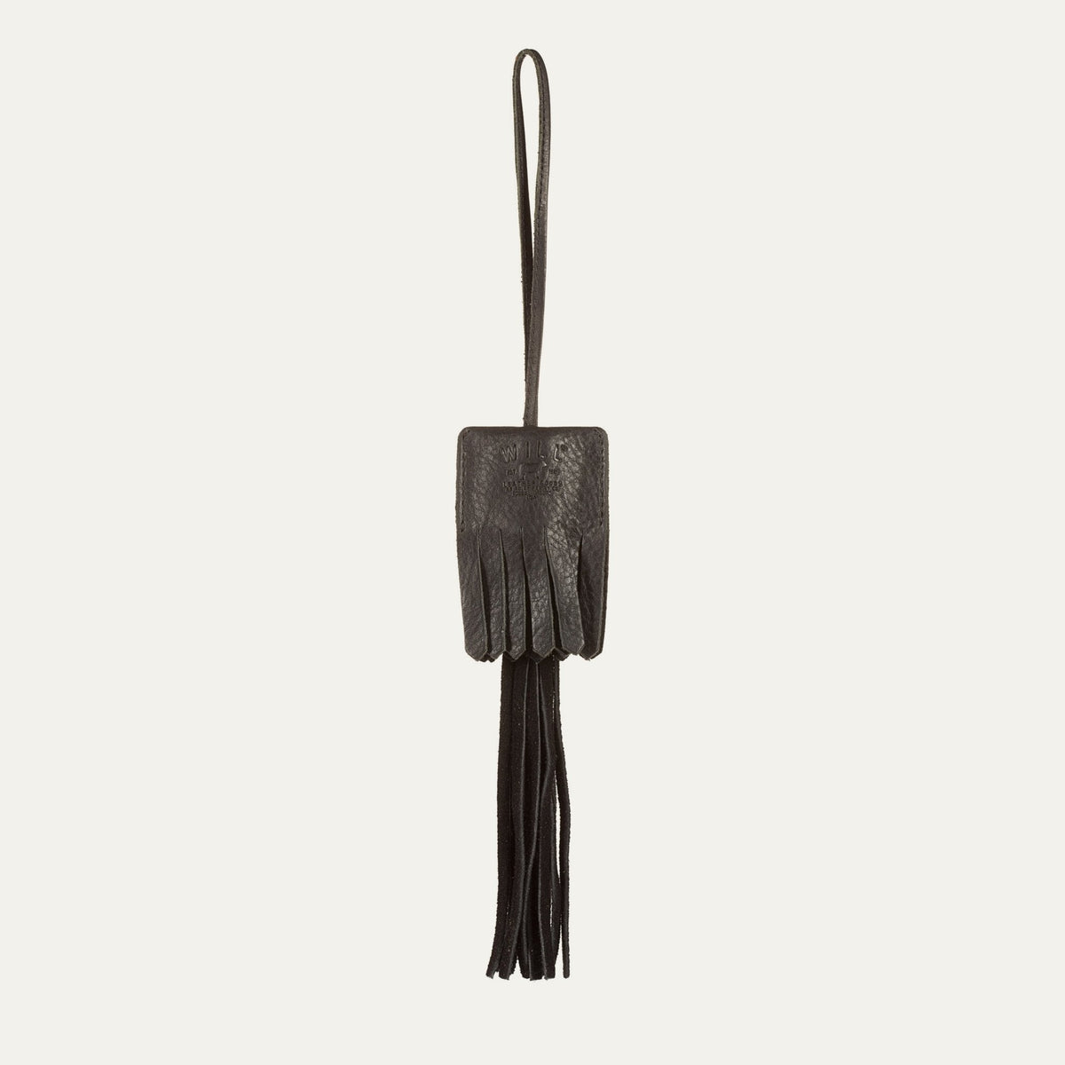 WILL Leather Goods key fob tassel in black leather, fringed tassel with embossed WILL Leather Goods patch and brass loop, on a white background.
