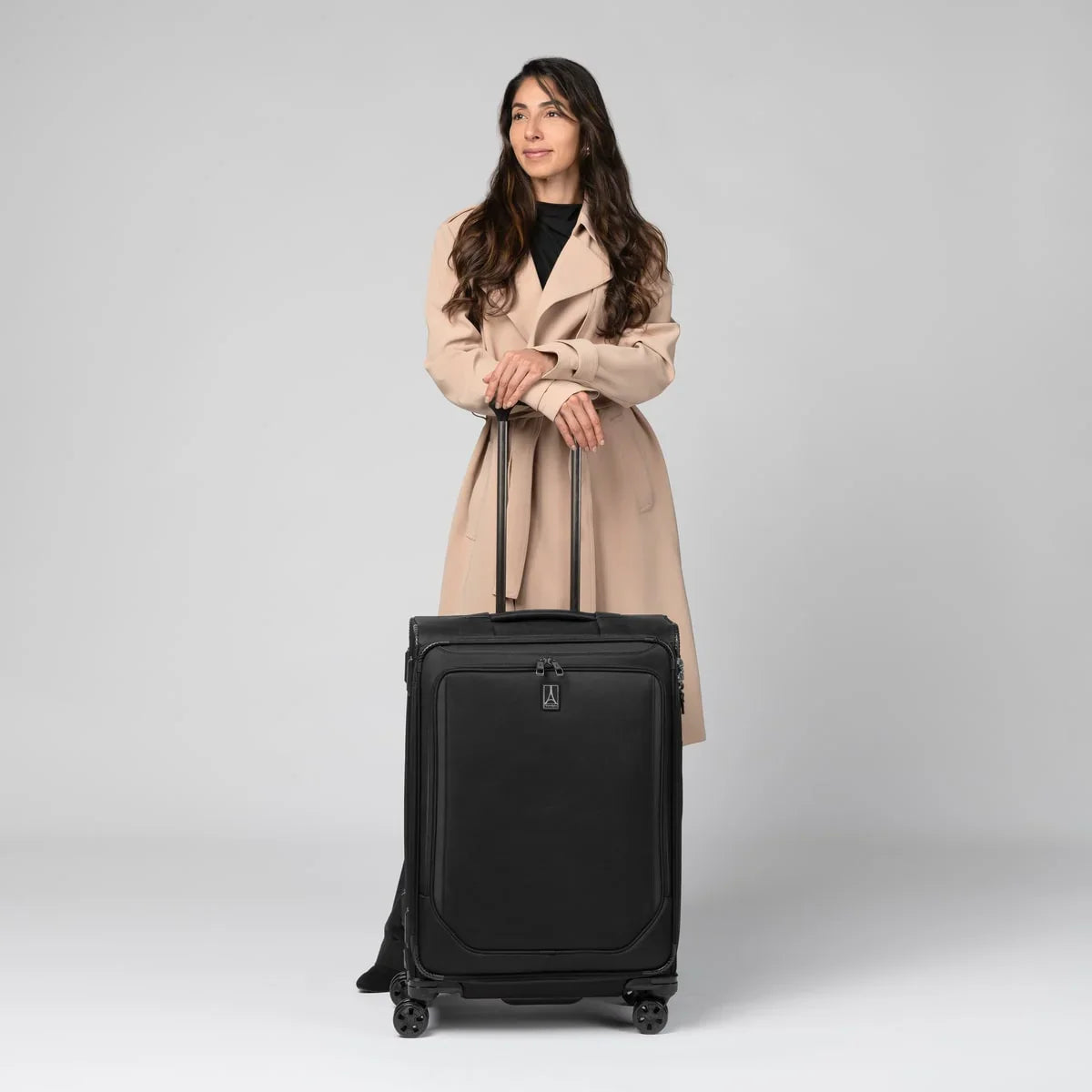 Traveler standing with the Travelpro Crew Classic medium check-in spinner