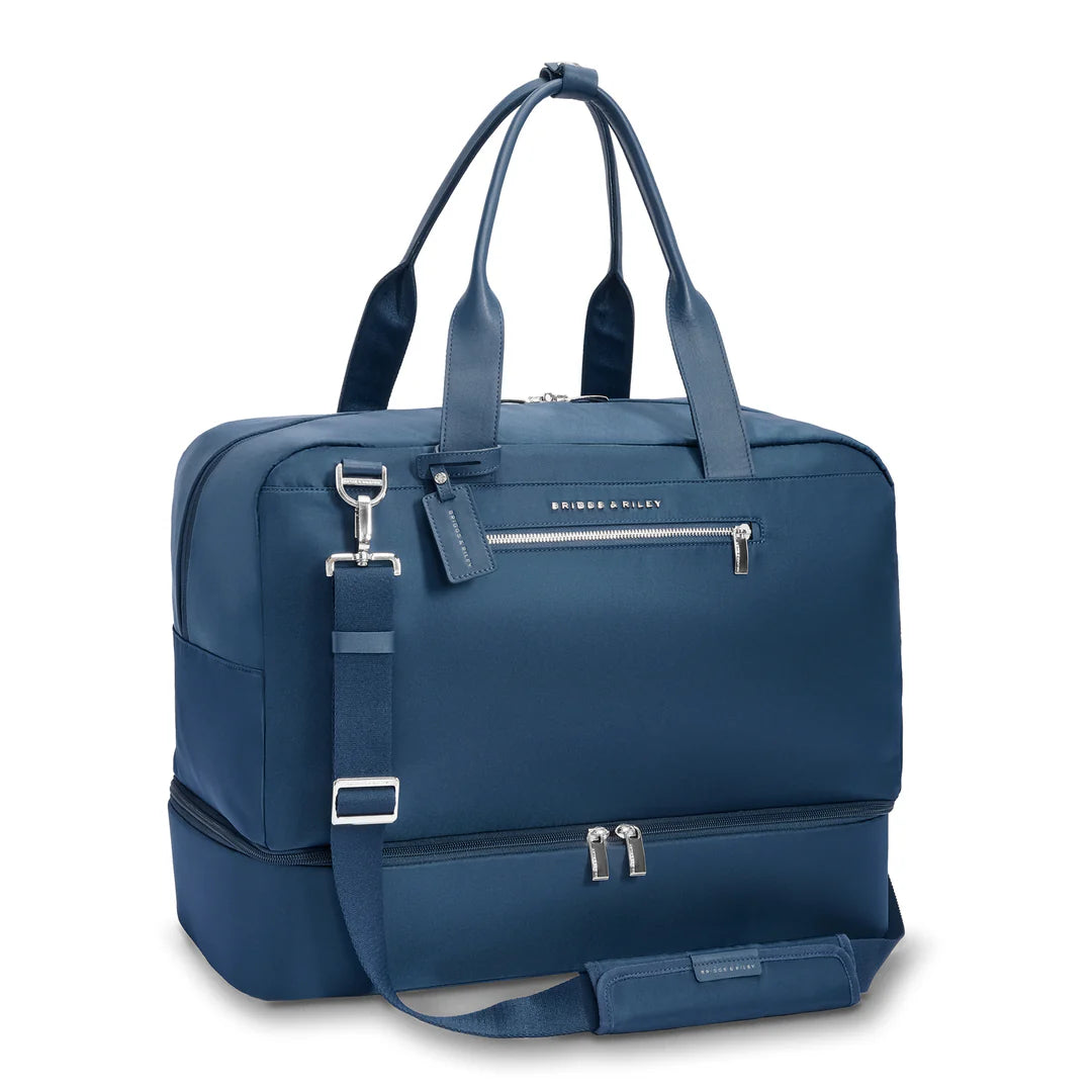 Briggs & Riley Rhapsody Weekender Tote in navy blue shown at an angle with the removable padded shoulder strap attached and the bottom zippered expansion compartment visible
