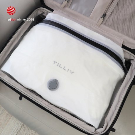 A white TILLIV Compak Large of compressed clothing sitting in an open suitcase
