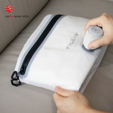 Hands steadying a white TILLIV Compak Small while a Nano Pump sits on its valve drawing the air out
