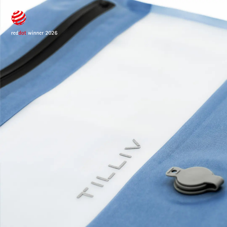 Close-up of a Steel Blue TILLIV Compak pack showing the embossed TILLIV logo, the grey one-way valve and the airtight zipper
