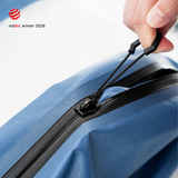 A hand drawing the hexagonal zipper tab along the airtight zipper of a Steel Blue TILLIV Compak pack