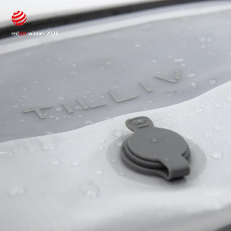Water beading on the surface of a white TILLIV Compak pack beside its one-way valve, showing the water-resistant coating