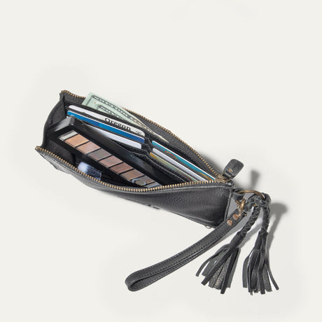 Will Leather Goods Two Zipper Pouch in black leather, open flat showing the interior filled with cash, an ID card, credit and gift cards, and a makeup palette and brush.