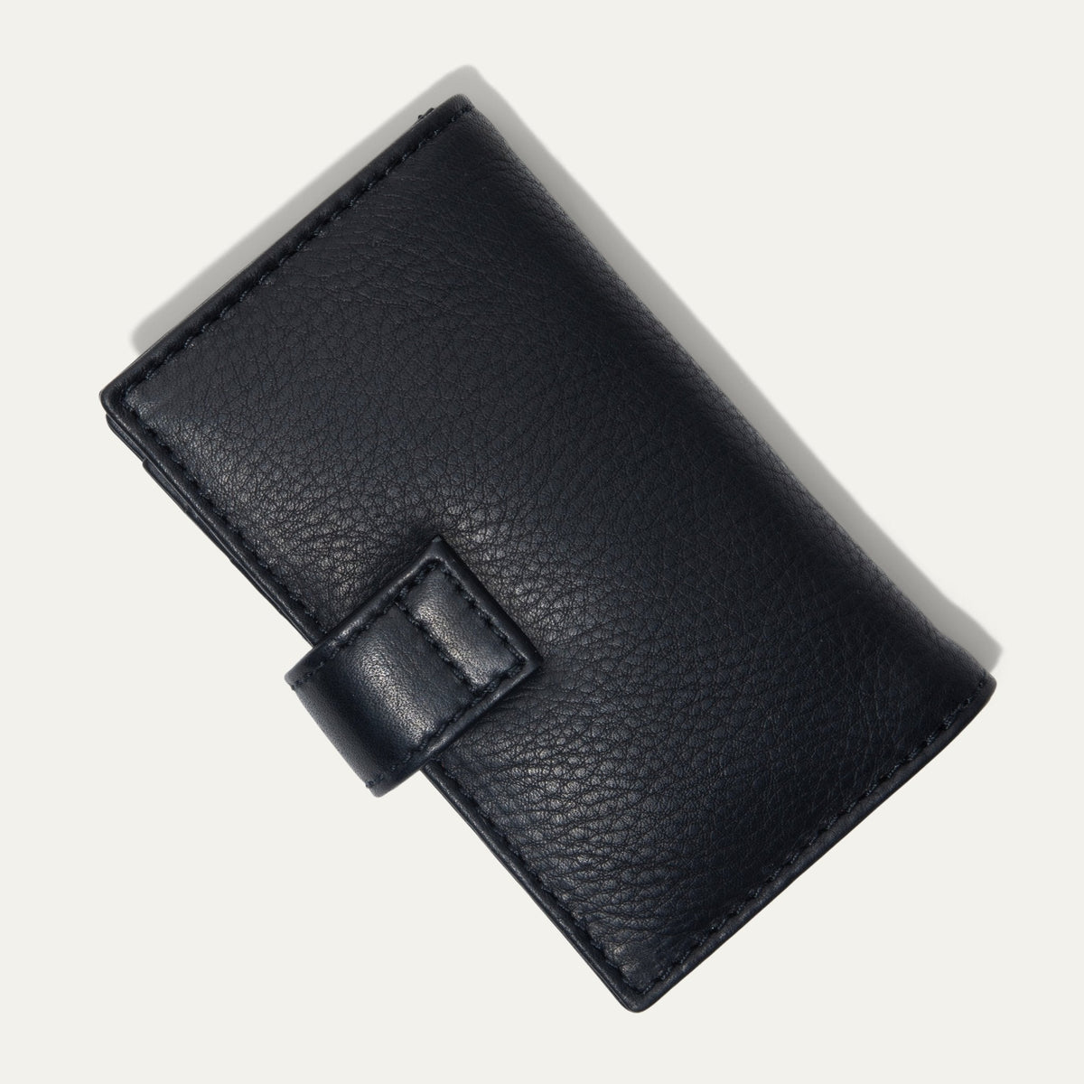 Will Leather Goods Signature Women's Cardholder Wallet in black leather, closed, angled front view with the snap-tab closure, on a white background.