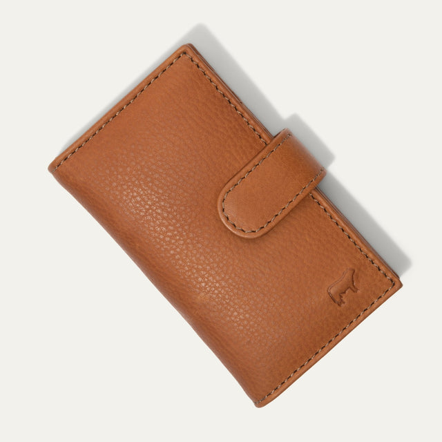 Will Leather Goods Signature Women's Cardholder Wallet in tan leather, closed with snap tab, embossed cattle-brand logo on the front, on a white background.