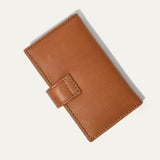 Will Leather Goods Signature Women's Cardholder Wallet in tan leather, closed, angled front view with the snap-tab closure, on a white background.