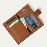 Tan leather cardholder wallet open, showing card slots, a clear ID window, and a cash pocket holding a bill, on a white background.