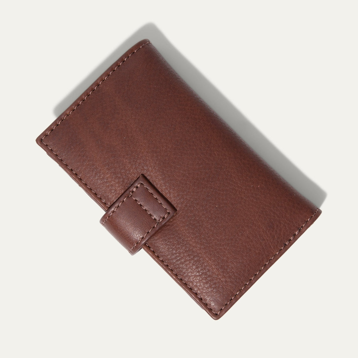 Will Leather Goods Signature Women's Cardholder Wallet in cognac leather, closed, angled front view with the snap-tab closure, on a white background.