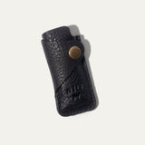 Black leather lighter cover with lighter partially visible, angled top-down view