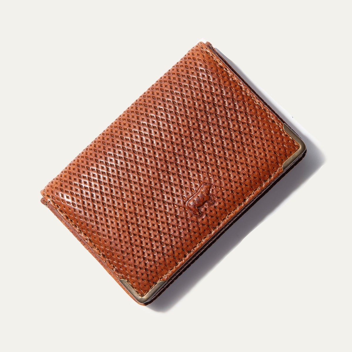 Will Leather Goods cognac pindot woven-texture leather business card holder, corner angle view with brass corner guard