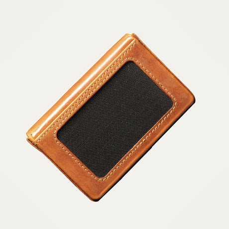 Cognac leather card holder open flat, showing business cards tucked into the pocket