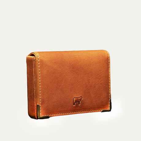 Angled close-up of the cognac leather card holder's ID window