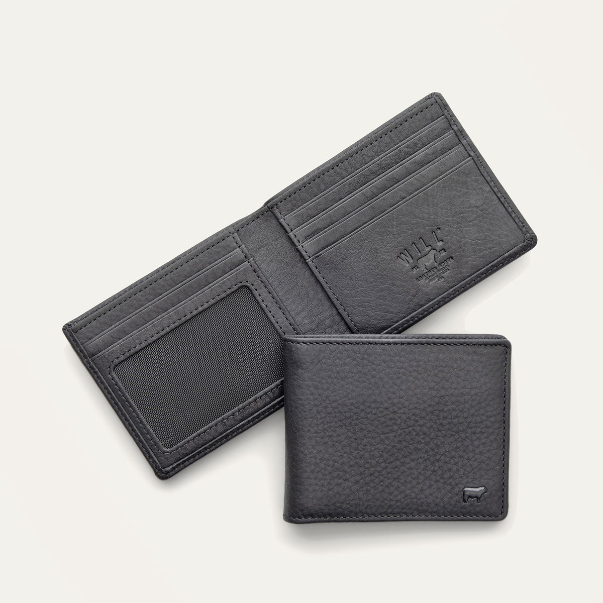 Will Leather Goods Classic Billfold Wallet in black leather, open showing card slots and an ID window, with a closed wallet resting in front showing the embossed cow logo.