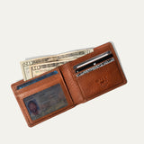 Will Leather Goods Classic Billfold Wallet in tan leather, open showing cash, an ID in the window pocket, credit cards, and the embossed WILL Leather Goods logo patch.