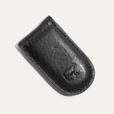 Angled close-up of the black Classic Money Clip holding cash, showing the stitched edge and embossed WILL cattle logo.