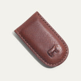 Angled close-up of the cognac Classic Money Clip holding cash, showing the stitched edge and embossed WILL cattle logo.