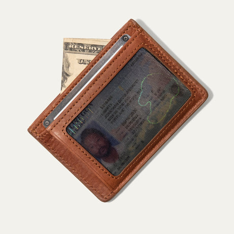 Tan leather card case with a bill tucked beside a card visible through the clear ID window, on a white background.