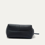 Bottom view of the black pebbled leather zip pouch, showing the boxed base seams