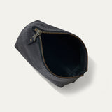 Black pebbled leather zip pouch open at the top, showing the empty black interior lining