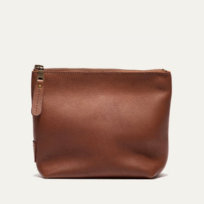 Cognac leather zip pouch shown straight-on, with the zipper pull and WILL leather patch visible on the front
