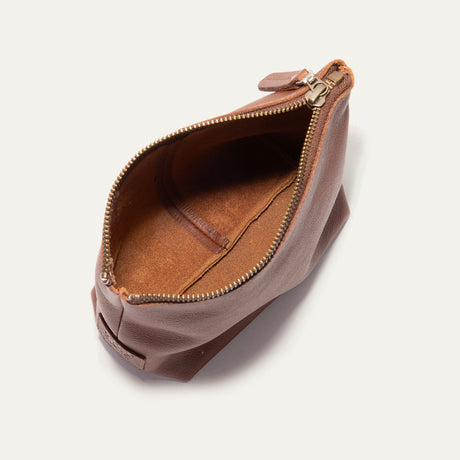 Cognac leather zip pouch open at the top, showing the empty tan suede-lined interior
