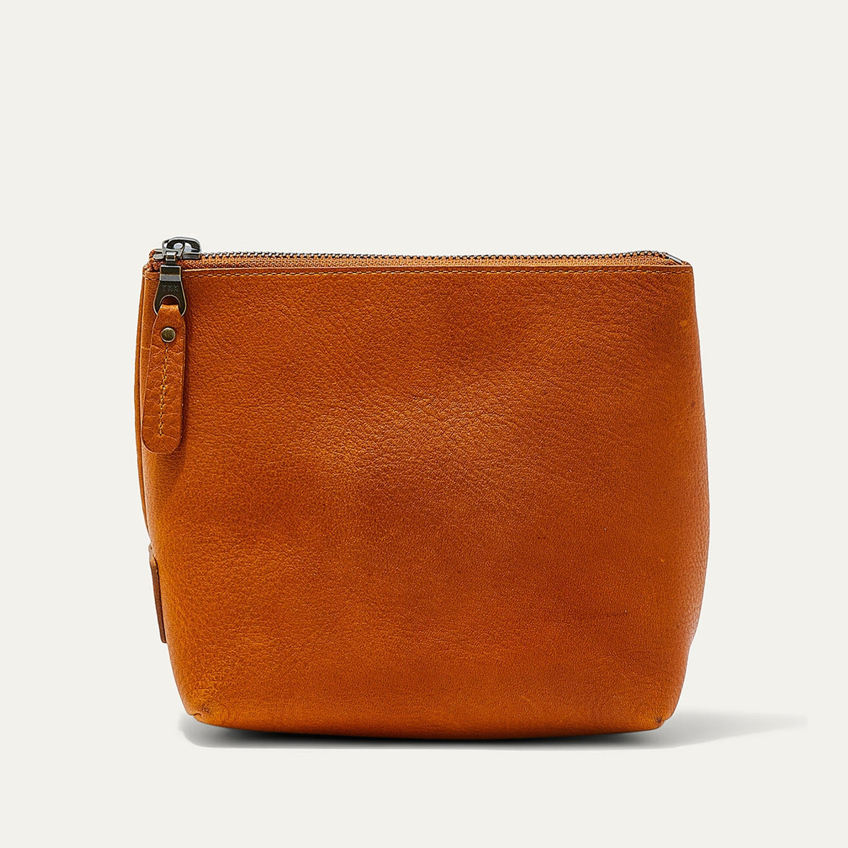 Tan leather zip pouch shown straight-on, with the zipper pull visible on the front