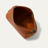 Tan leather zip pouch open at the top, showing the empty dark brown suede-lined interior