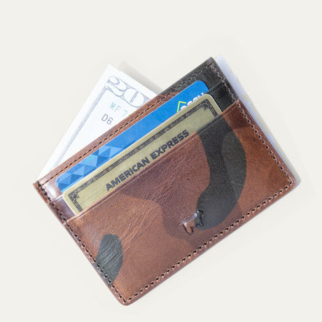Brown camo leather card case filled with cash and credit cards, including an American Express card