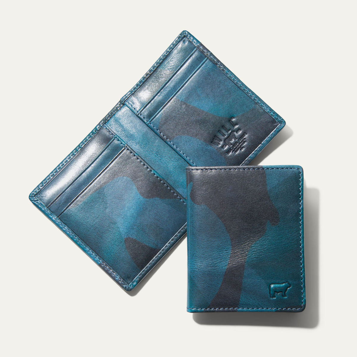 Military Front Pocket wallet in blue camouflage leather, shown open (trifold interior with card slots and embossed WILL logo) and closed, on a white background.