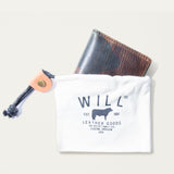The green camouflage Military Front Pocket wallet peeking out of a white WILL Leather Goods drawstring pouch.