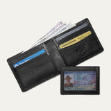 Companion Billfold Wallet by WILL Leather Goods in black leather, open with cash fanned out and a Chase Freedom card, American Express, and Delta SkyMiles card visible in the slots.