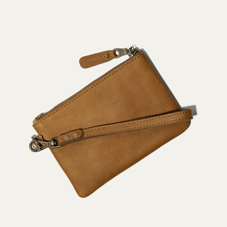 Tan leather zip pouch, three-quarter view with wristlet strap and clasp hardware