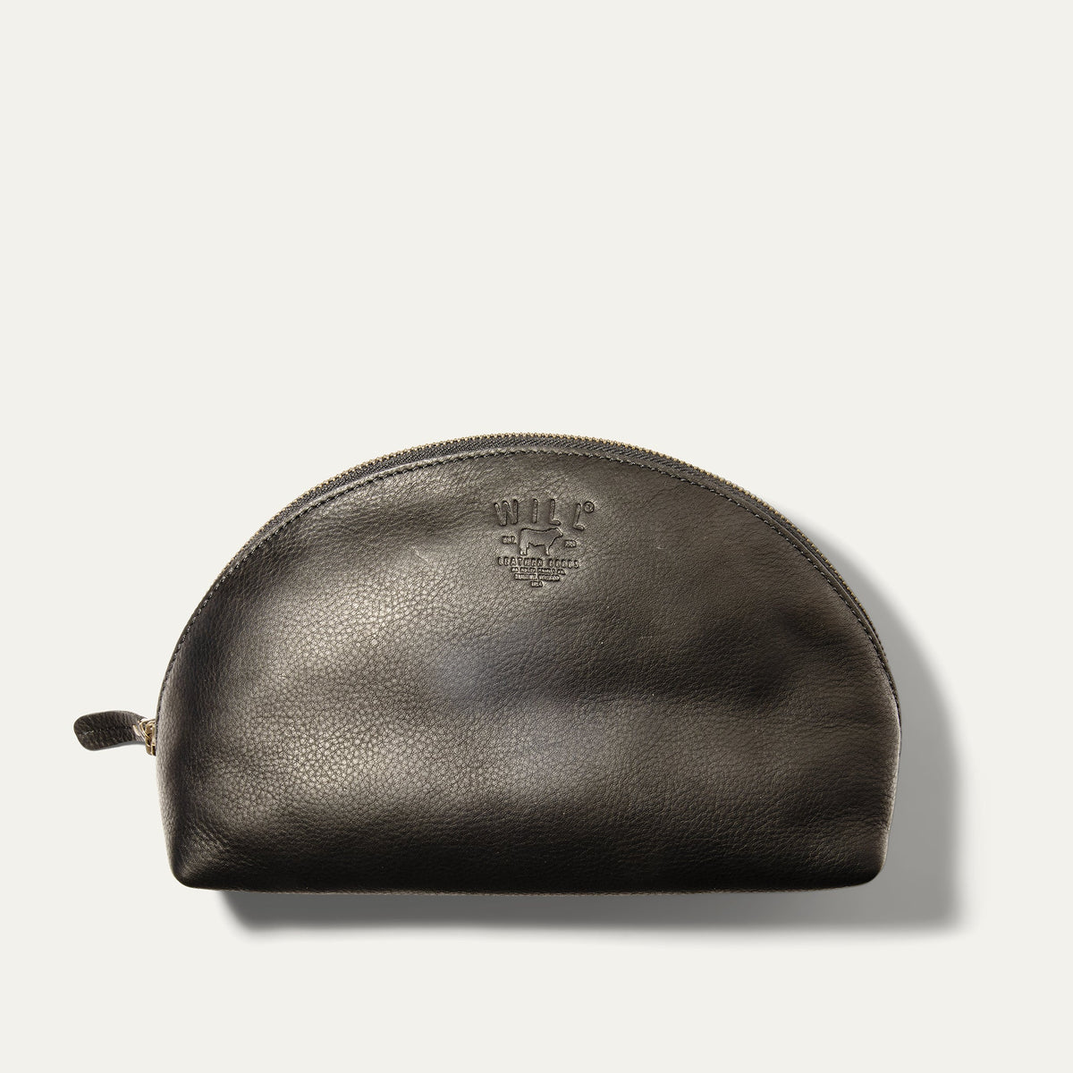 Will Leather Goods Zip Cosmetic bag in black leather, half-moon shape with brass zipper and embossed WILL logo, product shot on a white background.