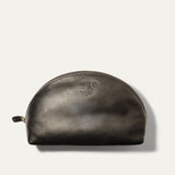 Will Leather Goods Zip Cosmetic bag in black leather, half-moon shape with brass zipper and embossed WILL logo, product shot on a white background.