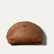 Will Leather Goods Zip Cosmetic bag in cognac leather, half-moon shape with brass zipper and embossed WILL logo, product shot on a white background.