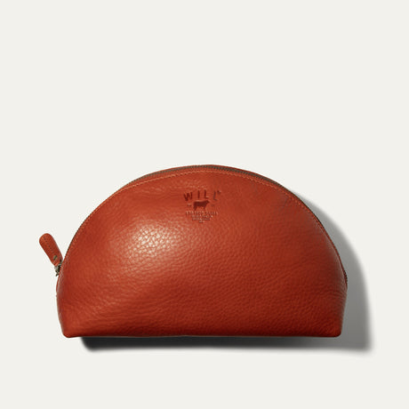 Will Leather Goods Zip Cosmetic bag in red leather, half-moon shape with brass zipper and embossed WILL logo, product shot on a white background.