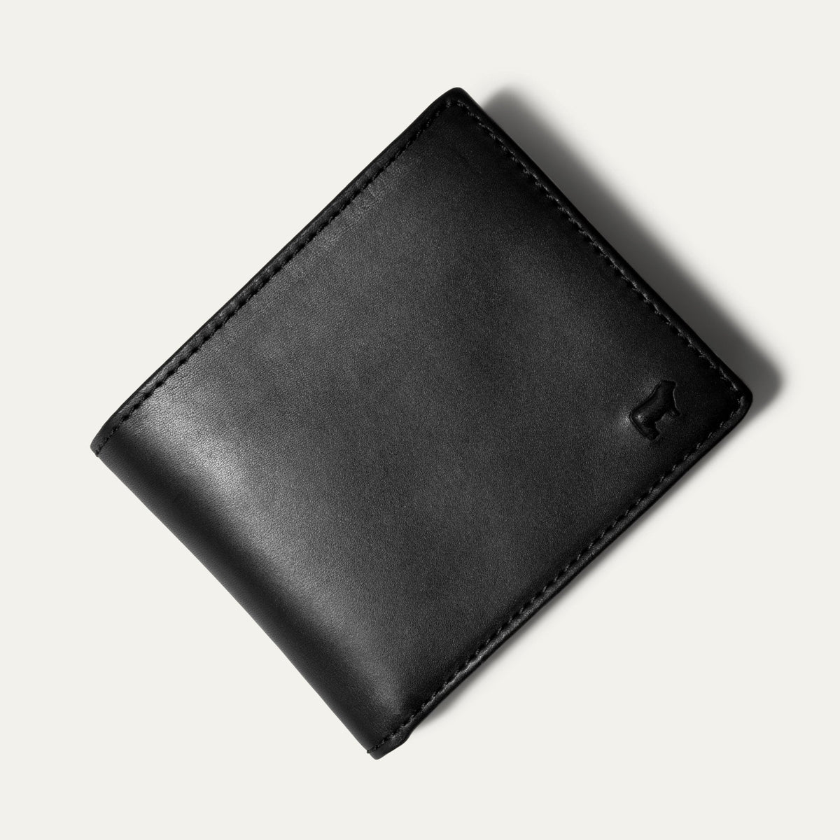 Black leather billfold wallet closed, straight-on front view, on a white background.