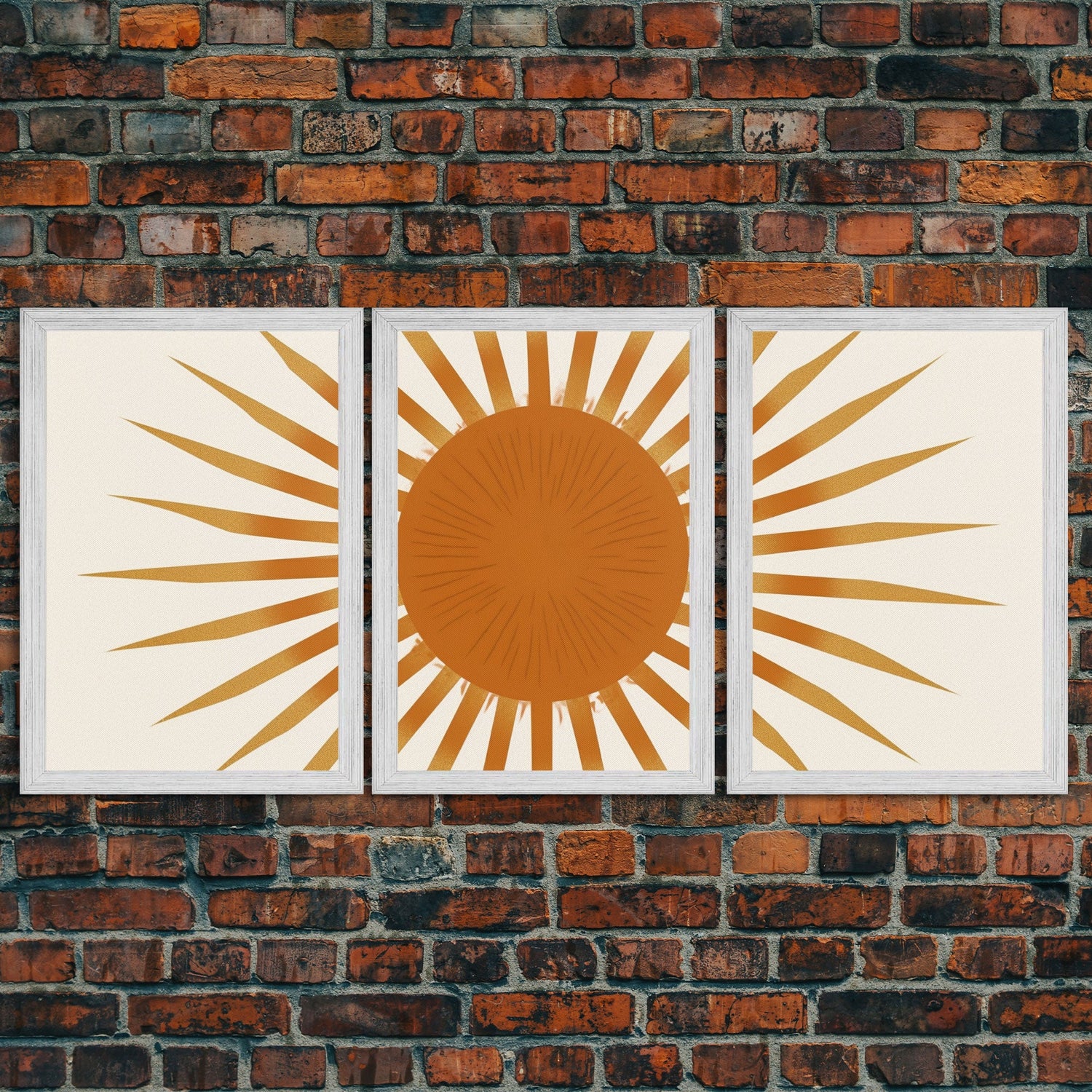 A triptych of framed Art Deco style prints mounted on an exposed brick wall, depicting a sunburst pattern with a large central sun and radiating golden rays. A triptych of framed Art Deco style prints mounted on an exposed brick wall, depicting a sunburst pattern with a large central sun and radiating golden rays.