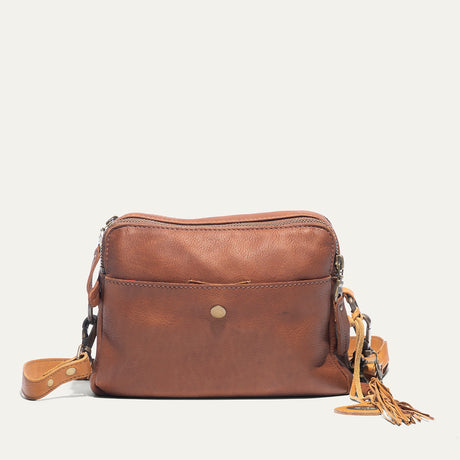 Cognac and tan leather crossbody bag, front view, with zip top, snap front pocket, and fringe tassel zipper pull