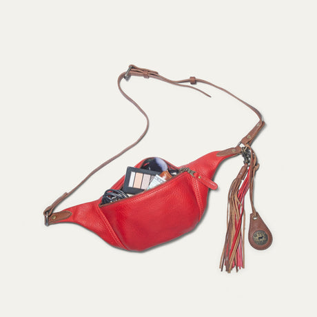 Red and cognac leather fanny pack unzipped, showing makeup, a wallet, and cash inside