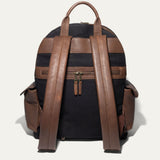 Back view of the black canvas Canvas + Leather Backpack showing the brown leather top handle, padded shoulder straps, and rear zip pocket.