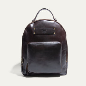 Dark brown leather round-top backpack with a top handle, front zip pocket, and embossed Will Leather Goods patch, front view.