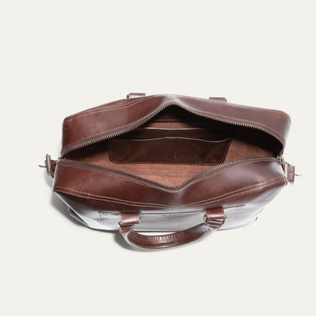 Top-down view of the dark brown leather briefcase open, showing the interior organizer pocket and suede lining