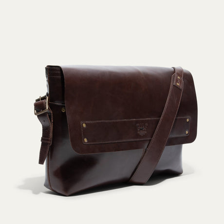 Will Leather Goods Field Messenger bag in dark brown leather, back view standing upright with the crossbody strap draped diagonally across the front.