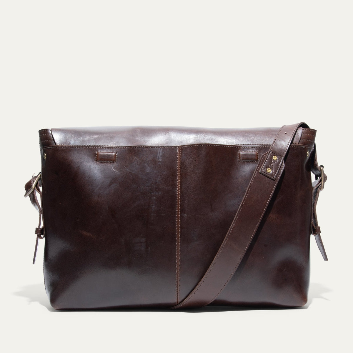 Will Leather Goods Field Messenger bag in dark brown leather, back view standing on a white background.