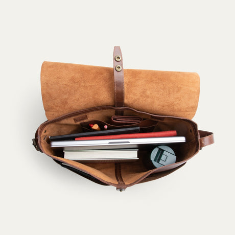 Will Leather Goods Field Messenger bag in tan leather, opened flat and empty showing the suede-lined interior, snap closure strap, and organizer pockets.
