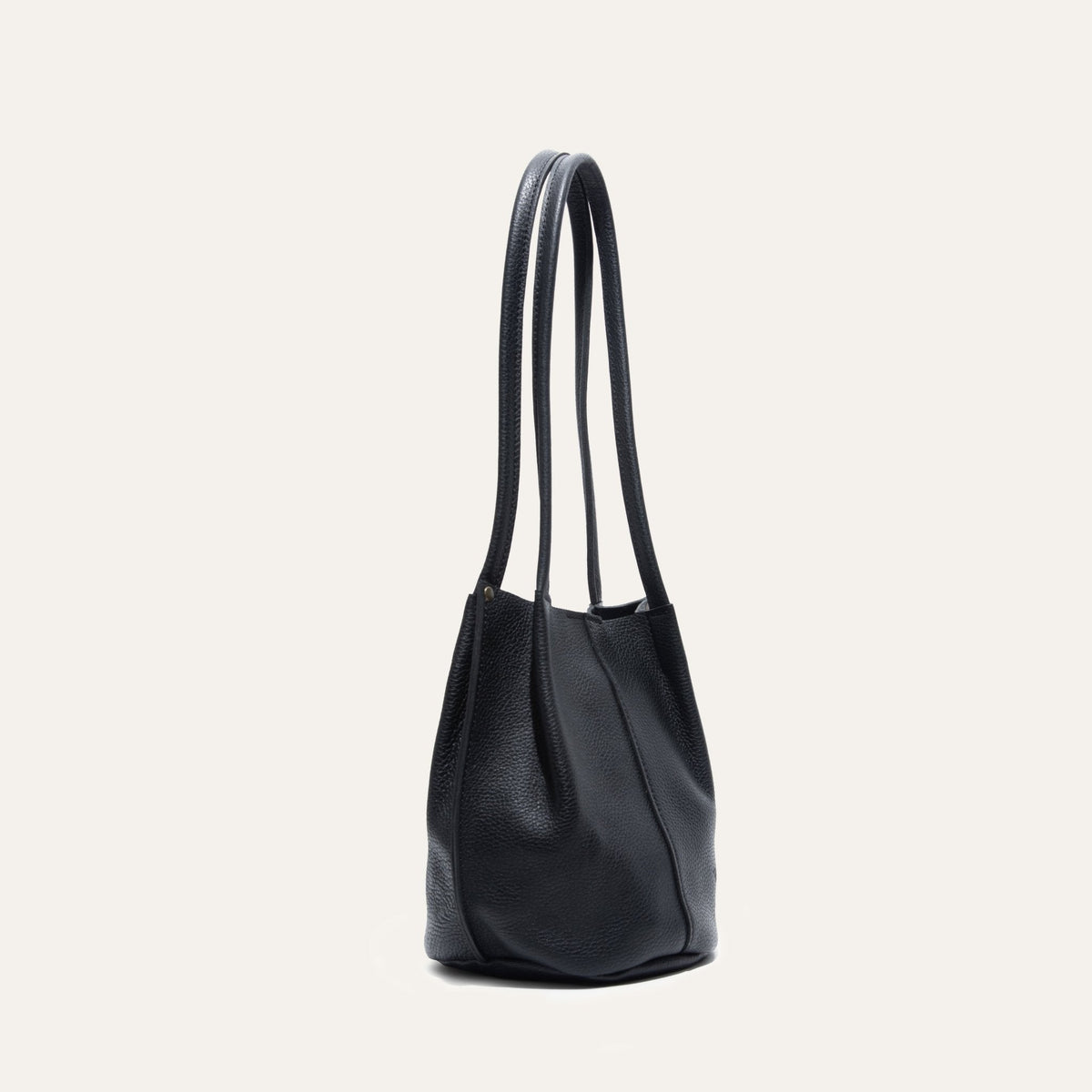 Black leather bucket bag, three-quarter angle view showing the shape and stitching